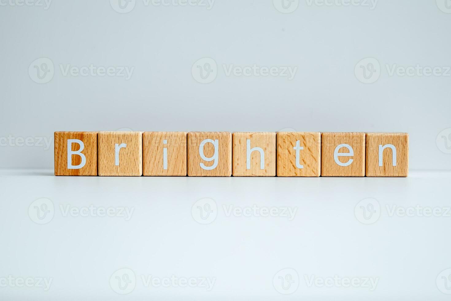 Wooden blocks form the text Brighten against a white background. photo