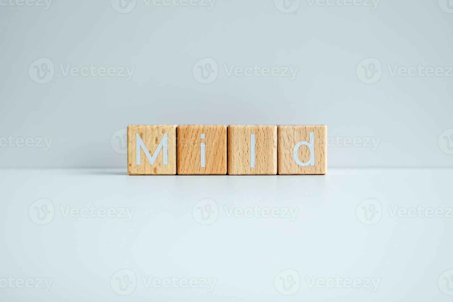 Wooden blocks form the text Mild against a white background. photo