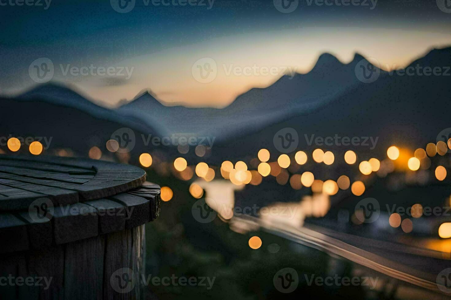a view of the mountains at dusk with lights on the ground. AI-Generated photo