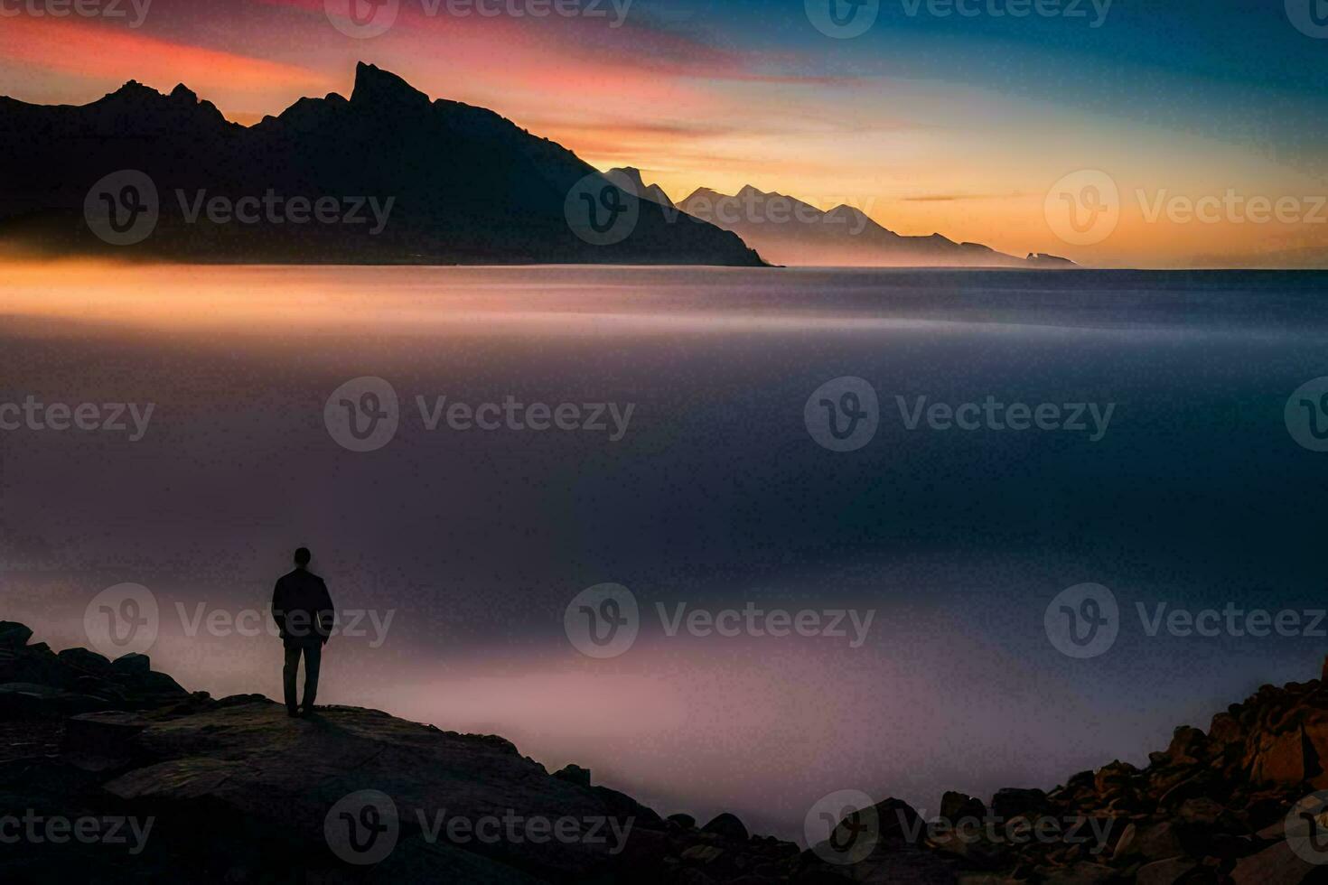 a man standing on a rock overlooking the ocean at sunset. AI-Generated photo