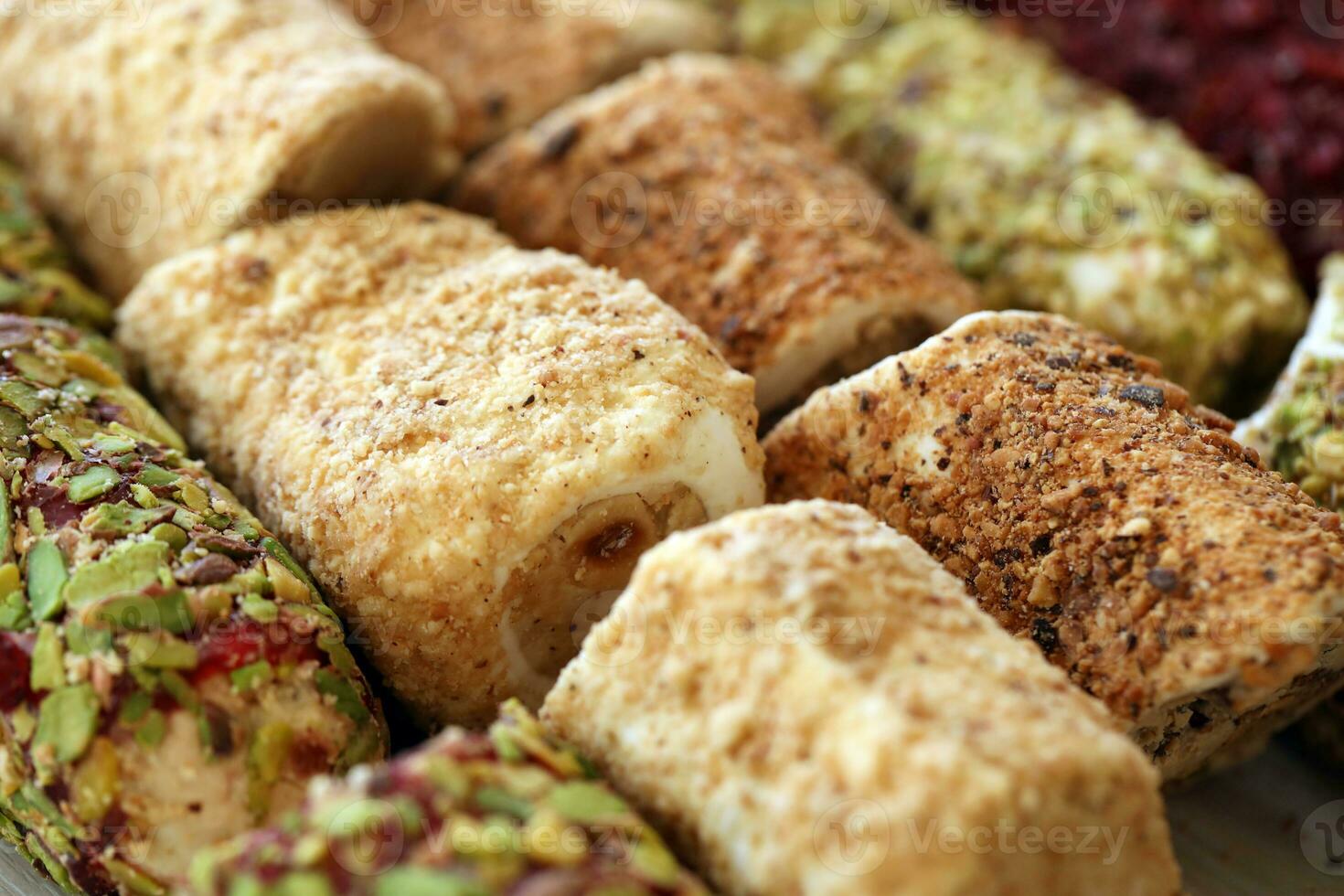 Rolls of turkish delight with many different flavors and fillings close up on table of vendors market photo