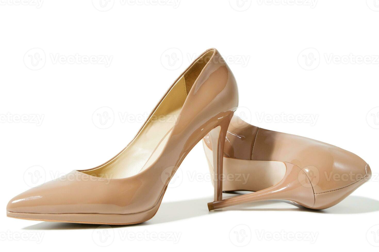 Close up shoe women. Beige patent female leather shoes isolated on white background. Woman high heels footwear on floor. Fashion and shopping concept. Top view. Copy space. Selective focus. photo