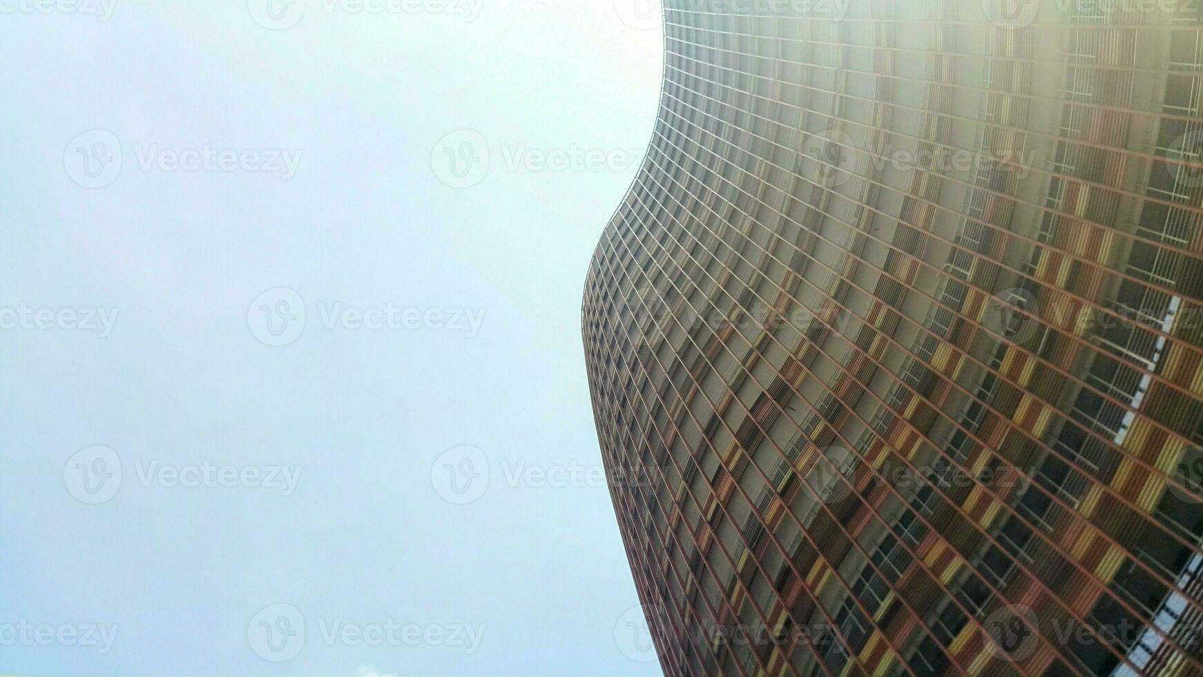 Bottom view of modern skyscrapers in business district against blue sky. Looking up at business buildings in downtown. photo