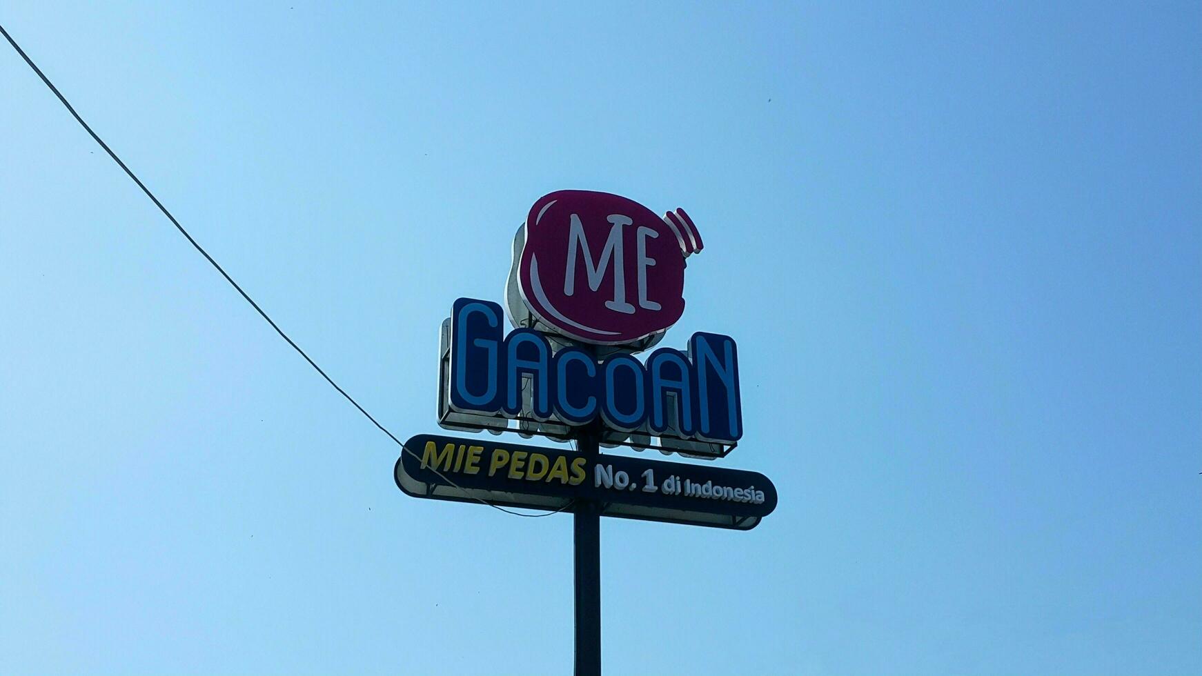 Mie Gacoan Sign with clear blue sky. A spicy noodle restaurant in Indonesia. photo
