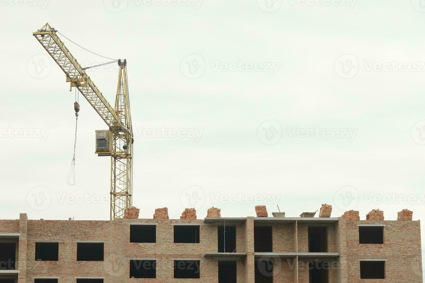 View of a large construction site with buildings under construction and multi-storey residential homes. Tower cranes in action on blue sky background. Housing renovation concept photo