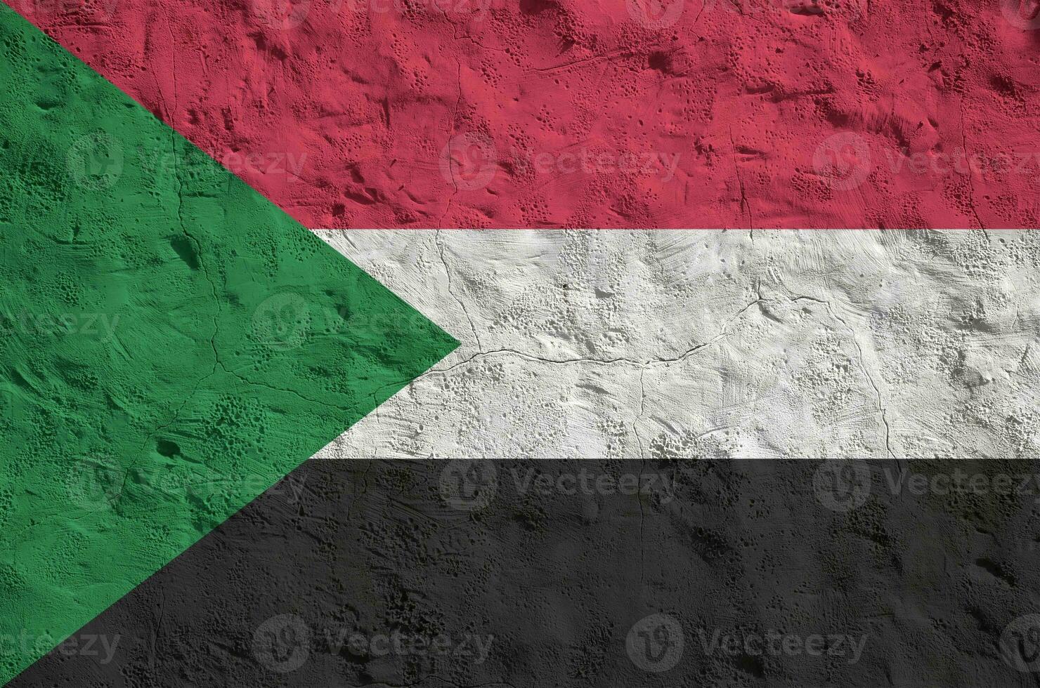 Sudan flag depicted in bright paint colors on old relief plastering wall. Textured banner on rough background photo