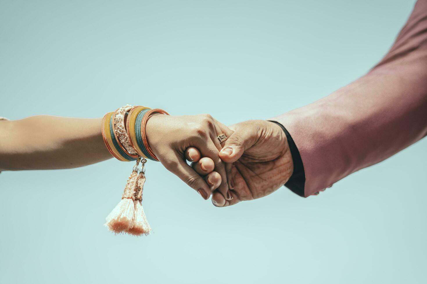 Multiracial couple holding hands together in love. Conceptual image of world unity interracial love and understanding in tolerance and diversity. photo