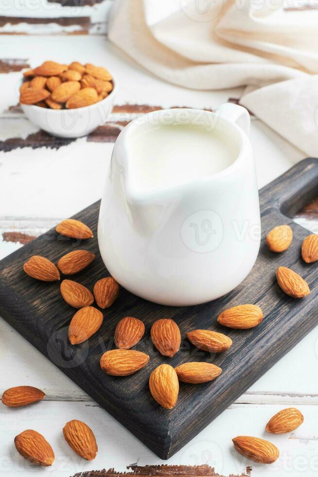 Almond milk in ceramic milk jug on a gray background. Copy space. photo