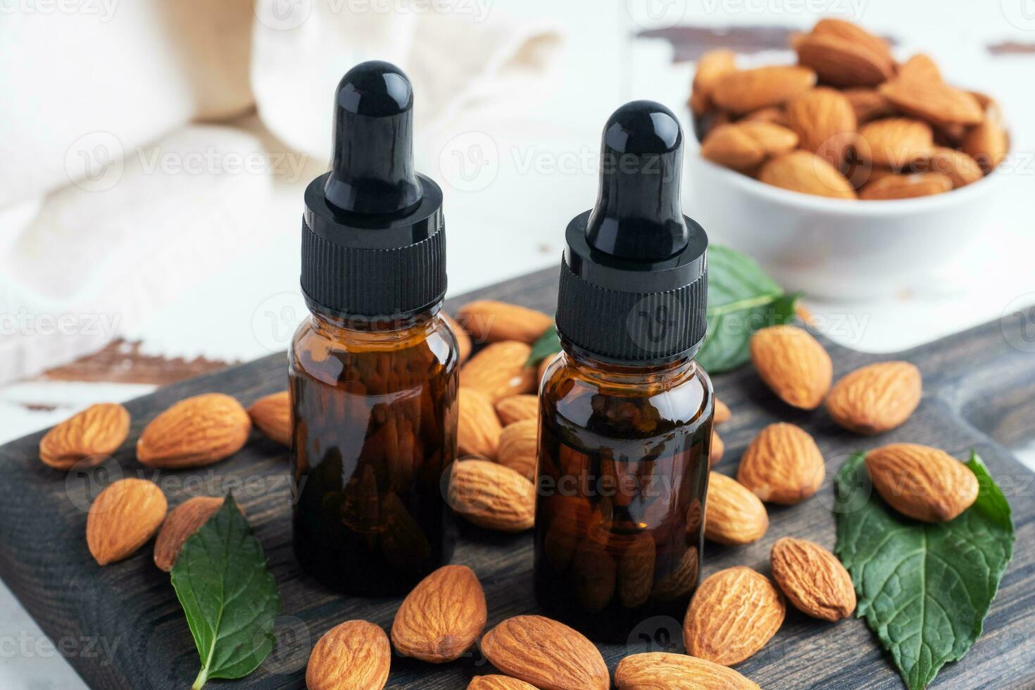 Almond essential oil in dark glass bubbles and fresh almond nuts. Aromatherapy oil natural organic cosmetic. photo