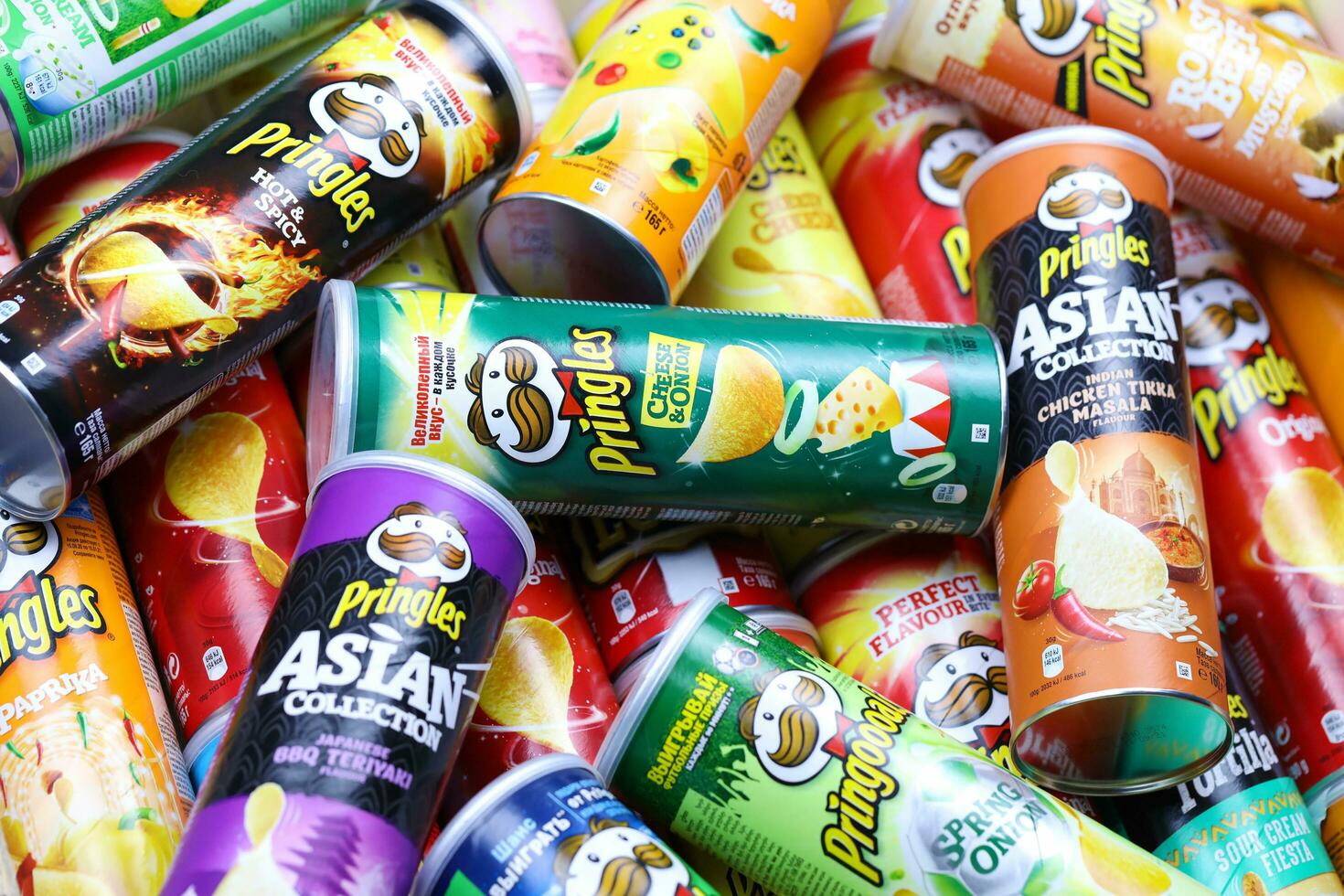 KHARKOV, UKRAINE - MARCH 30, 2021 Many Pringles cylinder chips boxes with varios colors and flavours. American brand of stackable potato-based crisps photo