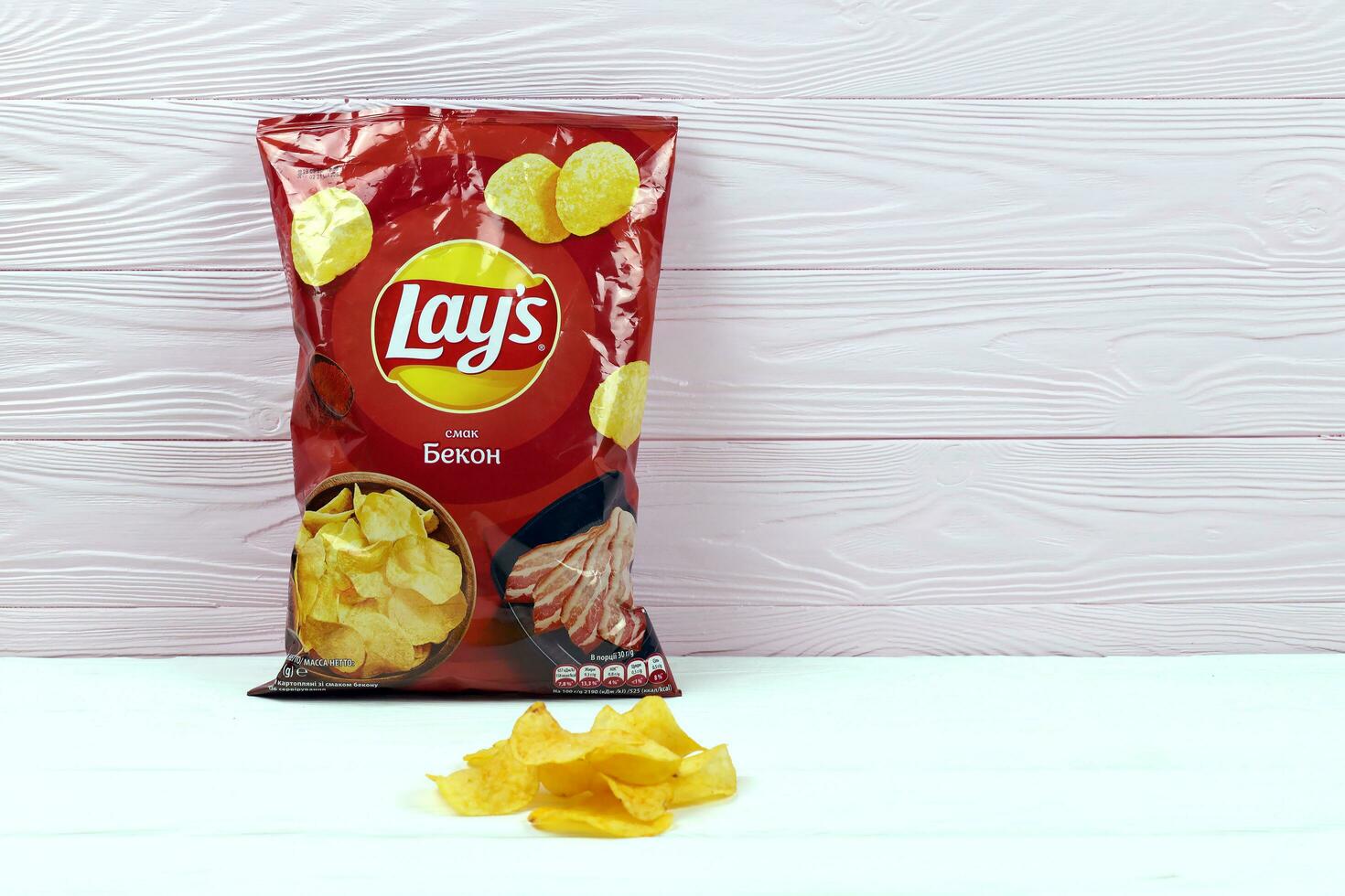 KHARKOV, UKRAINE - JANUARY 3, 2021 Lays potato chips with bacon flavour and original lays logo in middle of package. Worldwide famous brand of potato chips photo