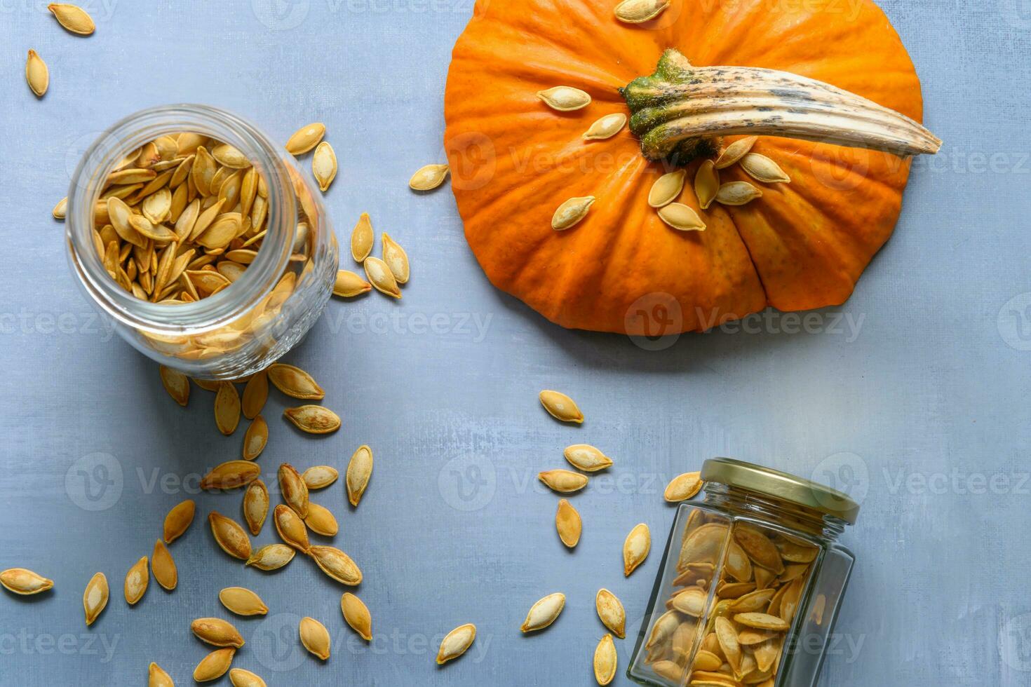 Two jars with pumpkin seeds on a rustic table photo