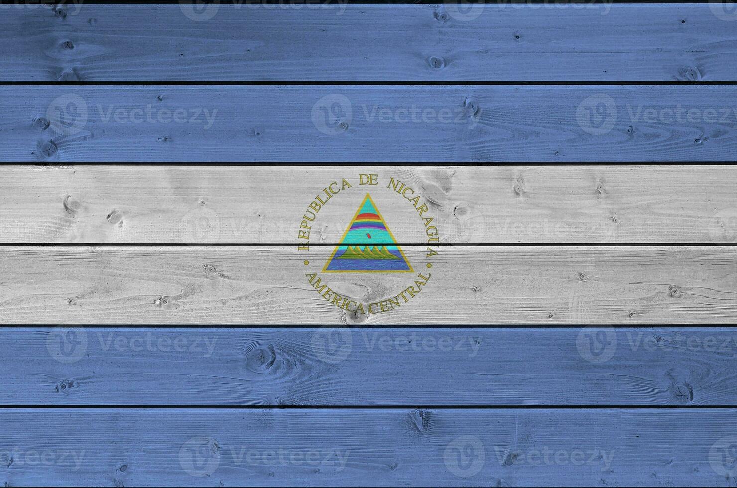 Nicaragua bandera representado en brillante pintar colores en antiguo de madera pared. texturizado bandera en áspero antecedentes foto