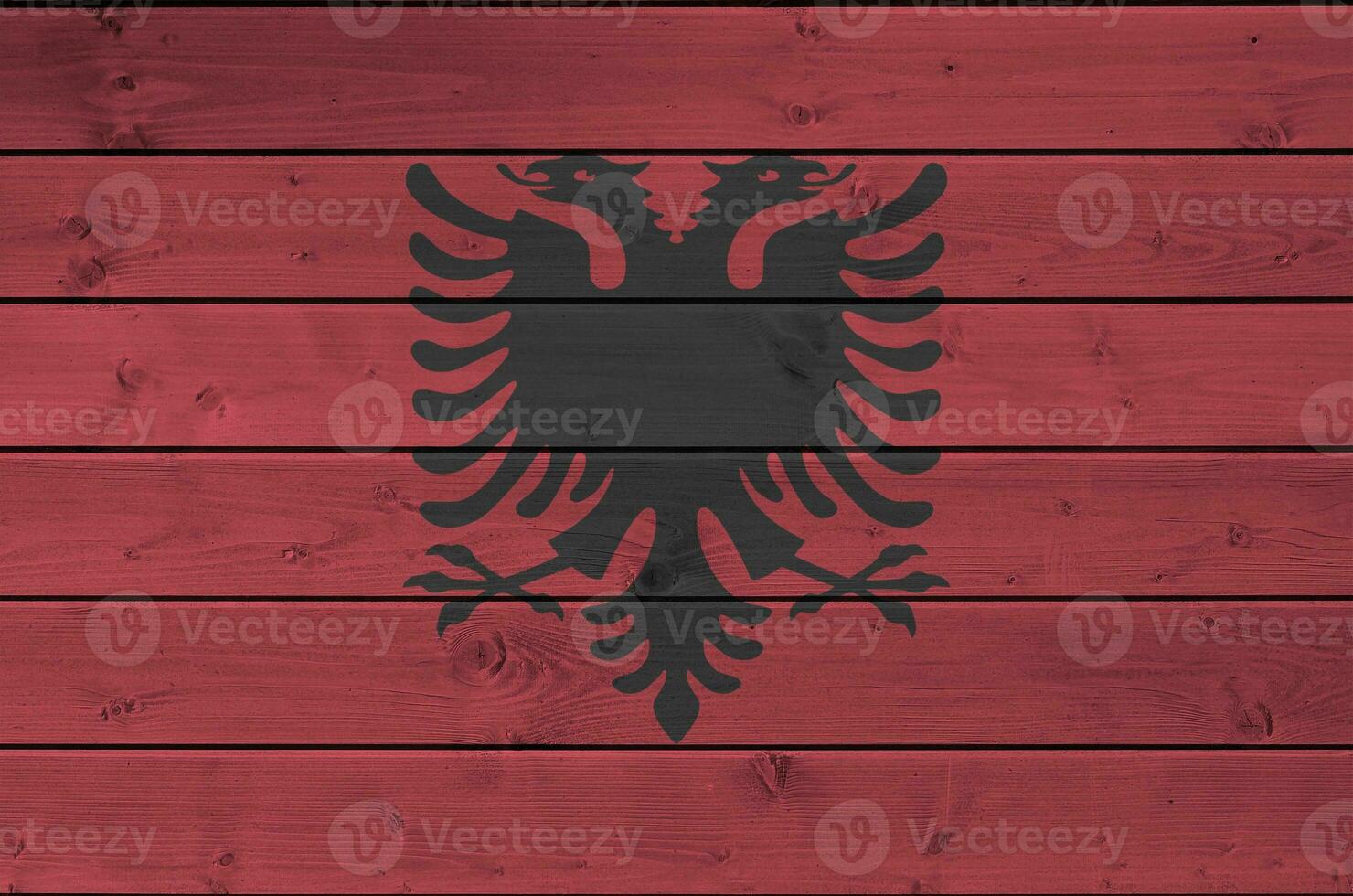 Albania bandera representado en brillante pintar colores en antiguo de madera pared. texturizado bandera en áspero antecedentes foto