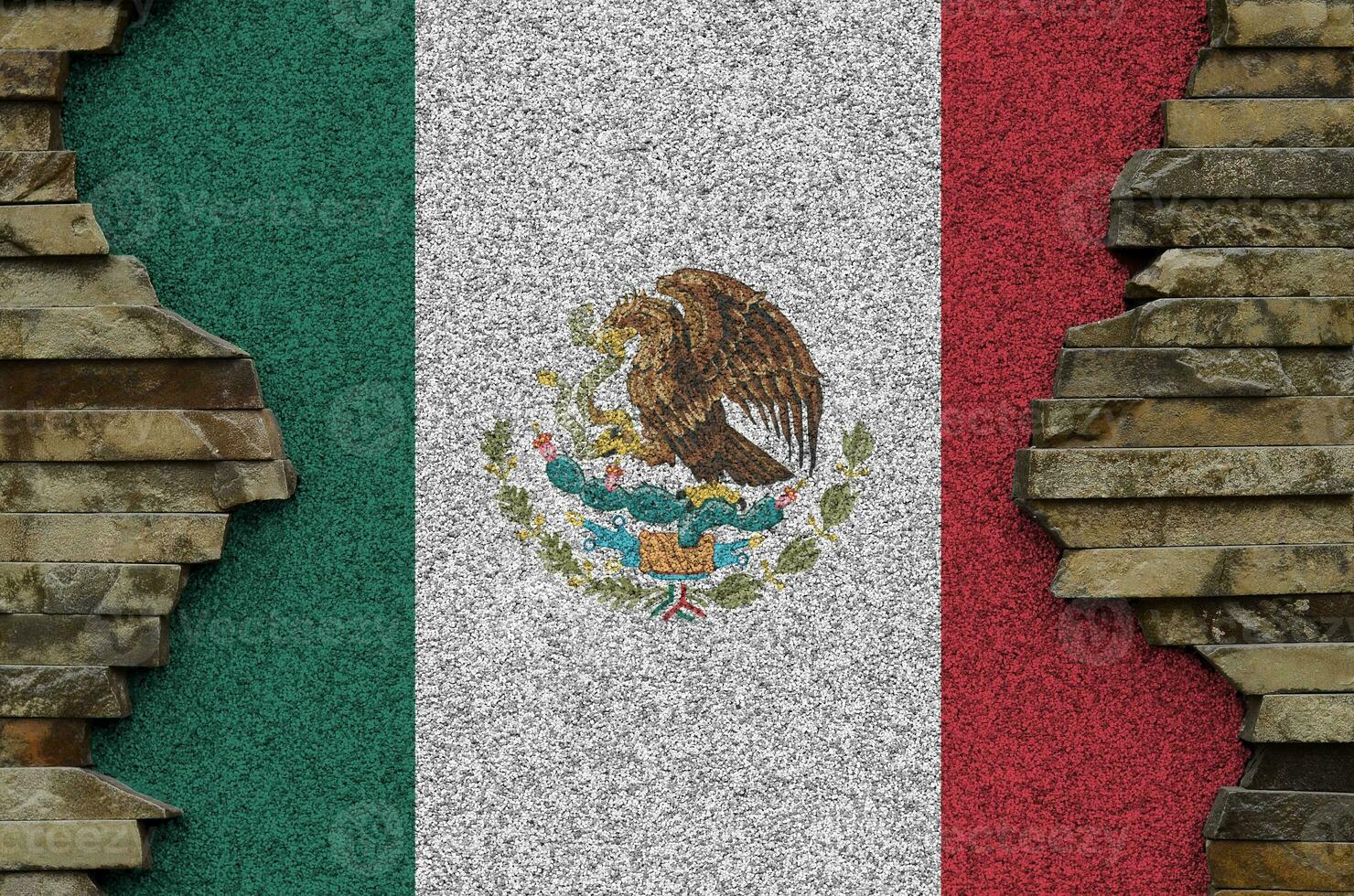 Mexico flag depicted in paint colors on old stone wall closeup. Textured banner on rock wall background photo