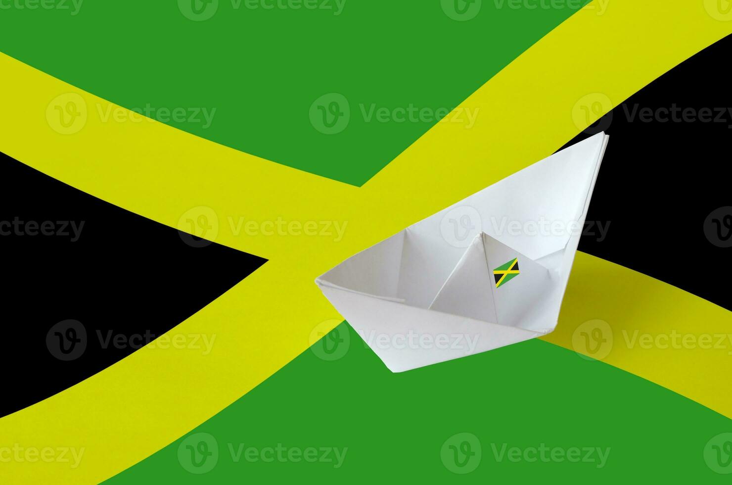 Jamaica flag depicted on paper origami ship closeup. Handmade arts concept photo