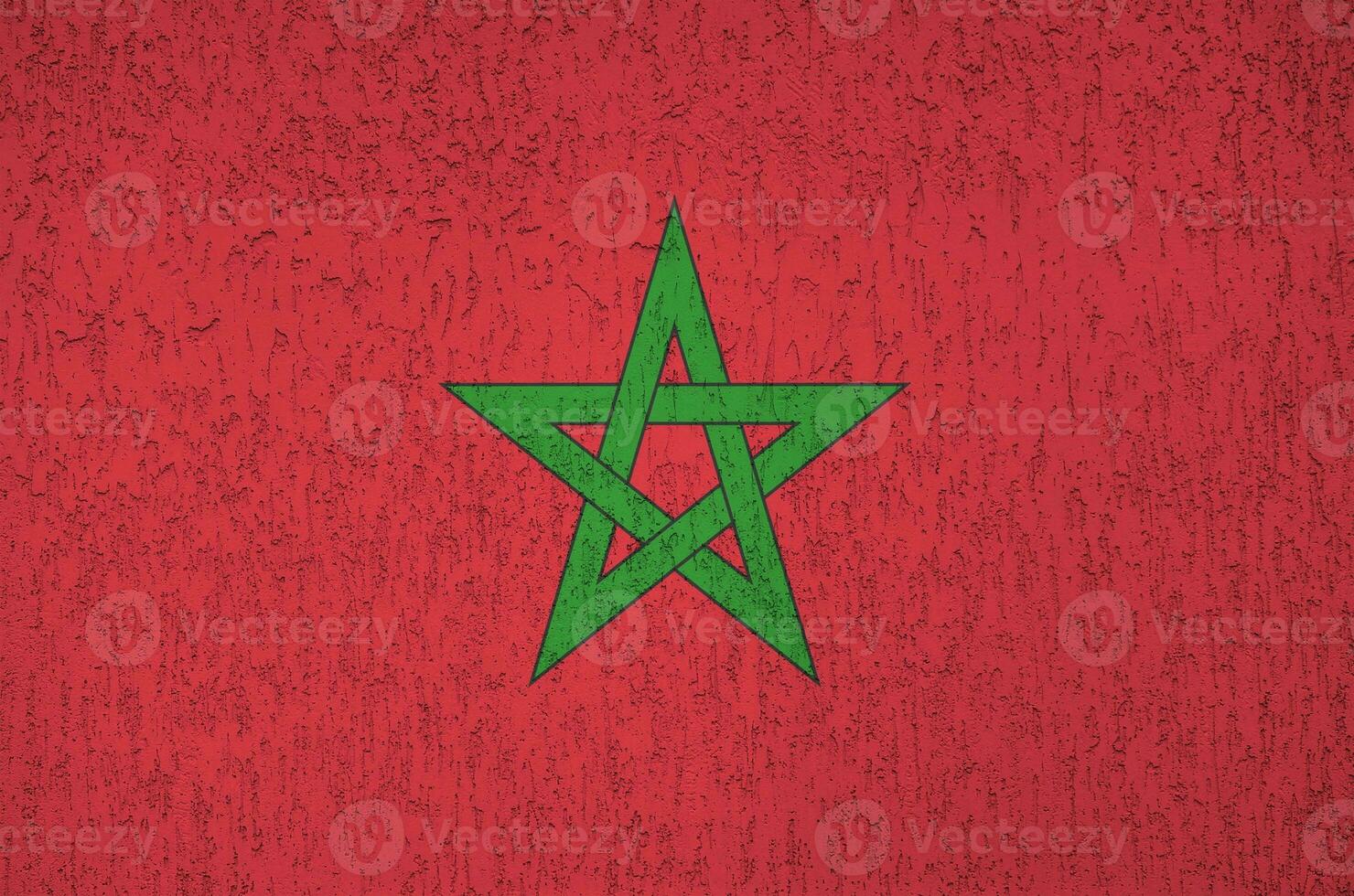 Morocco flag depicted in bright paint colors on old relief plastering wall. Textured banner on rough background photo