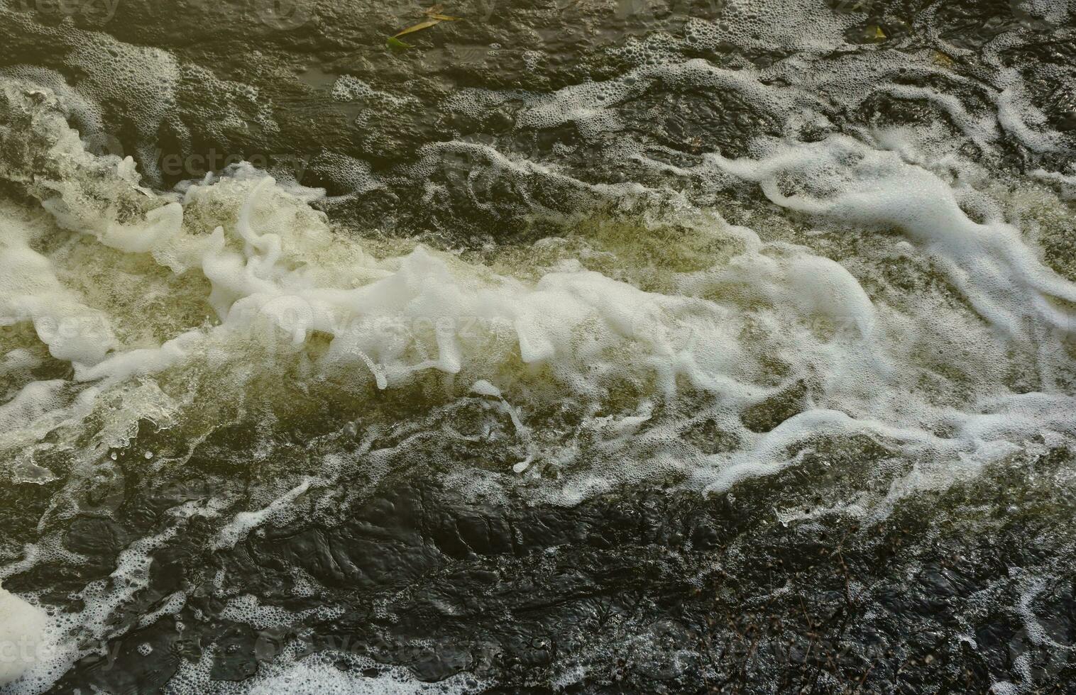 Waves of water of the river and the sea meet each other during high tide and low tide. Deep blue stormy sea water surface with white foam and waves pattern, background photo