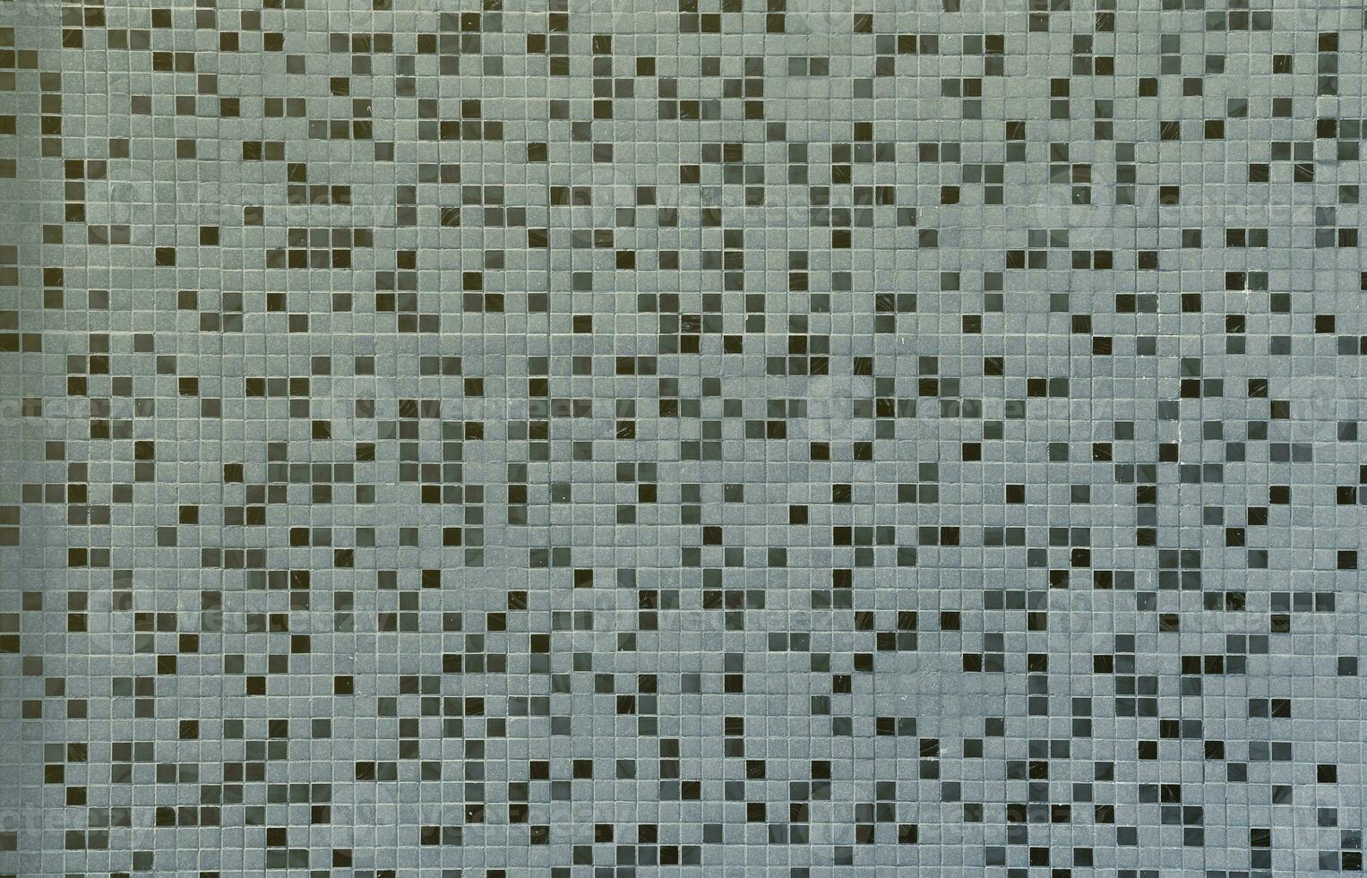 The texture of the wall, decorated with a mosaic of various small square tiles. Abstract pattern of ceramic tiles on the wall photo