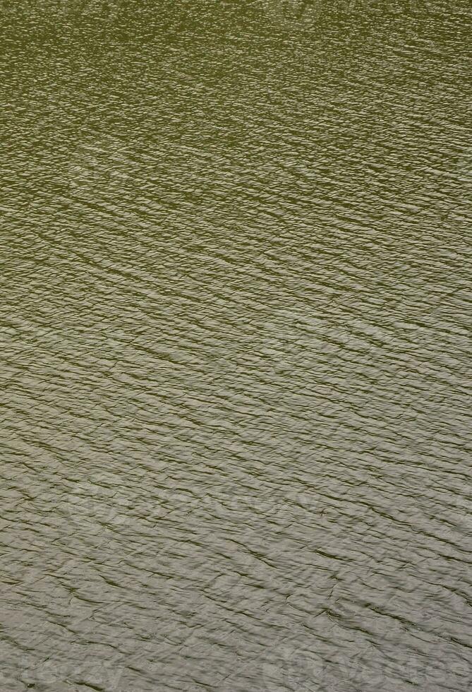 la textura del agua oscura del río bajo la influencia del viento, impresa en perspectiva. imagen vertical foto