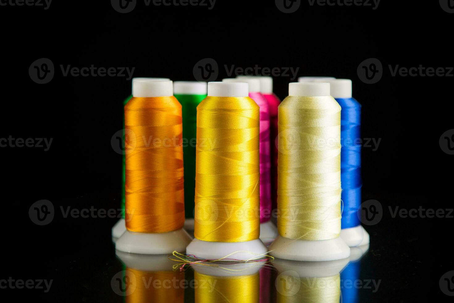 set of different color sewing threads,on black background. photo