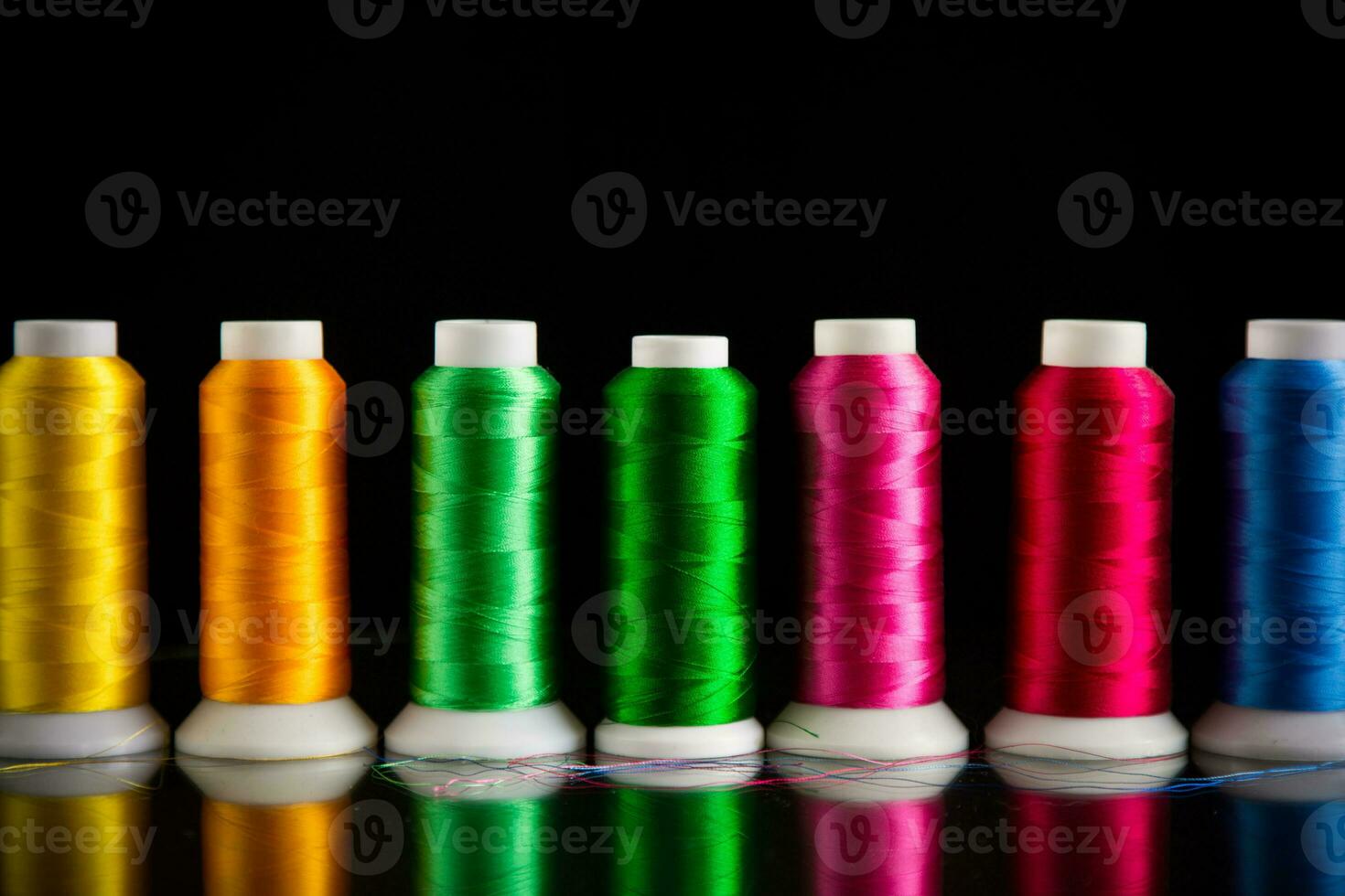 set of different color sewing threads,on black background. photo