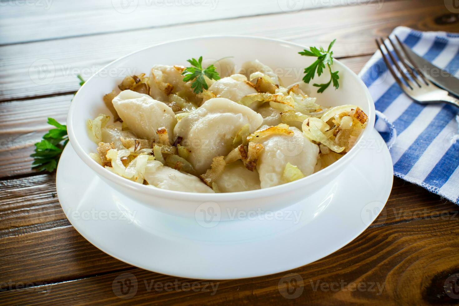 Ukrainian Vareniky or Pierogi stuffed with potato and mushrooms, served with fried onion. photo