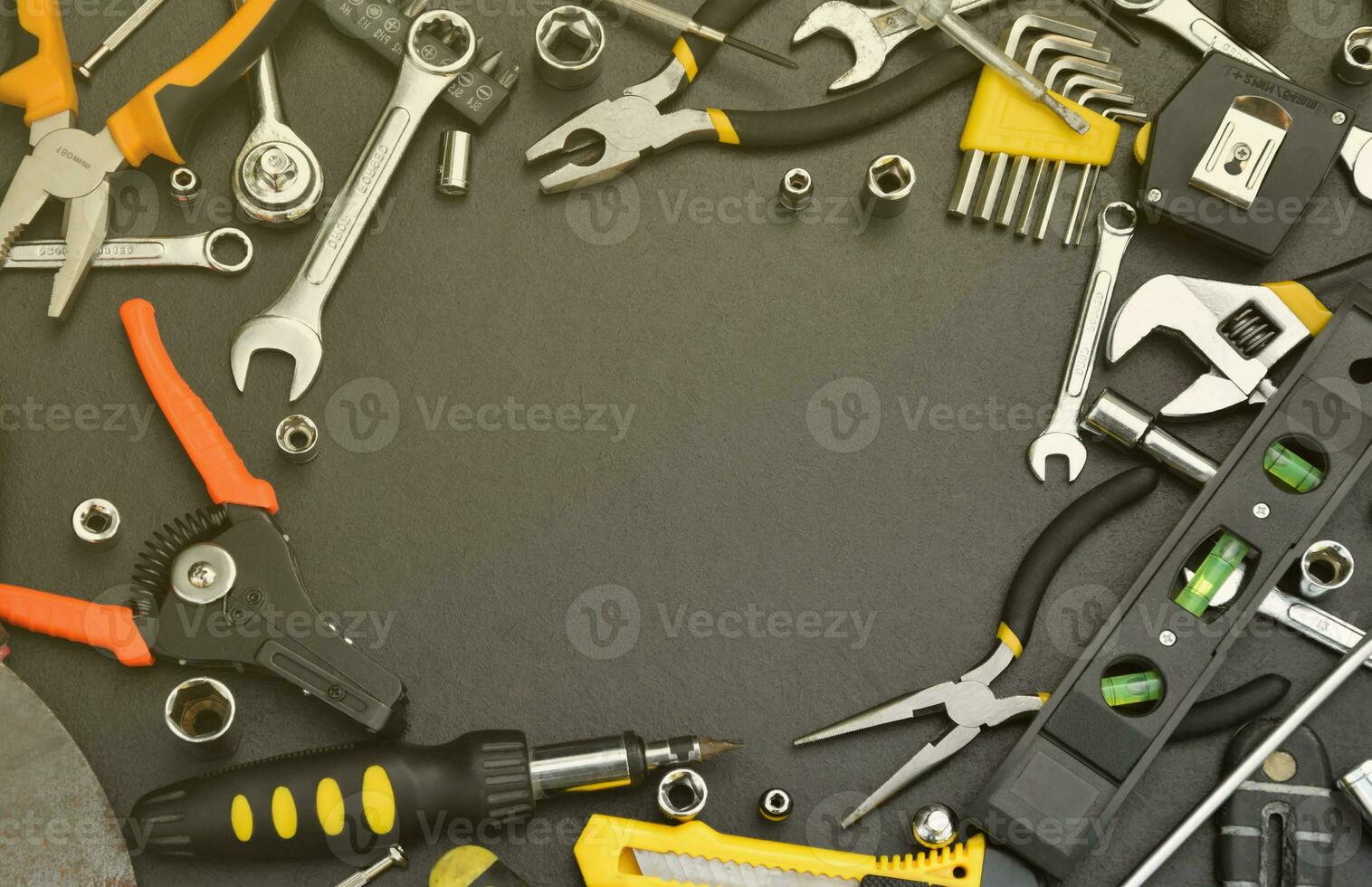 Handyman tool kit on black wooden table with copy space. Many wrenches and screwdrivers, pilers and other tools for any types of repair or construction works. Repairman tools photo