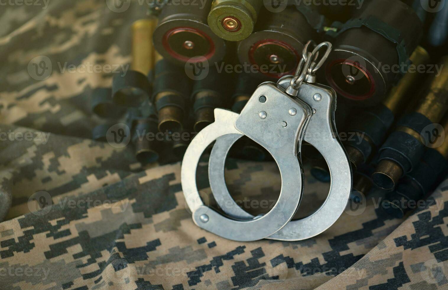 Ukrainian army machine gun belt shells and handcuffs on military uniform. Concept of bribery and war crimes photo
