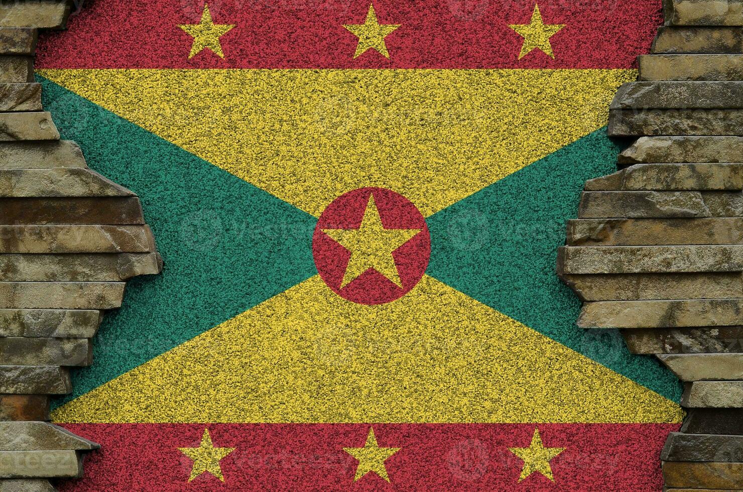 Grenada flag depicted in paint colors on old stone wall closeup. Textured banner on rock wall background photo