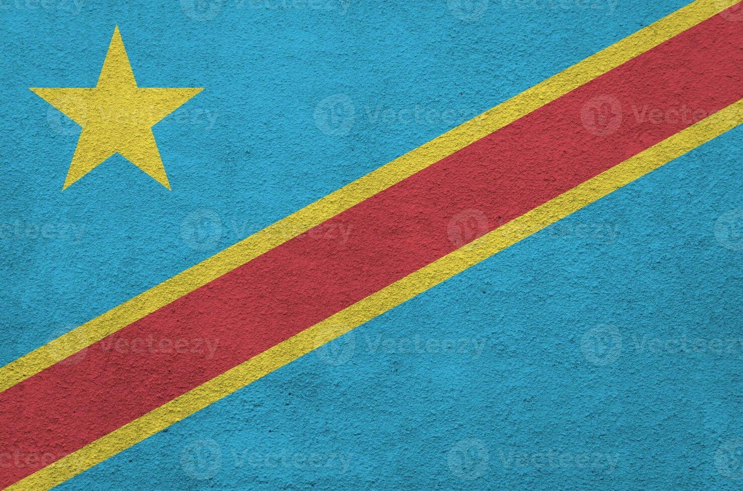 Democratic Republic of the Congo flag depicted in bright paint colors on old relief plastering wall. Textured banner on rough background photo