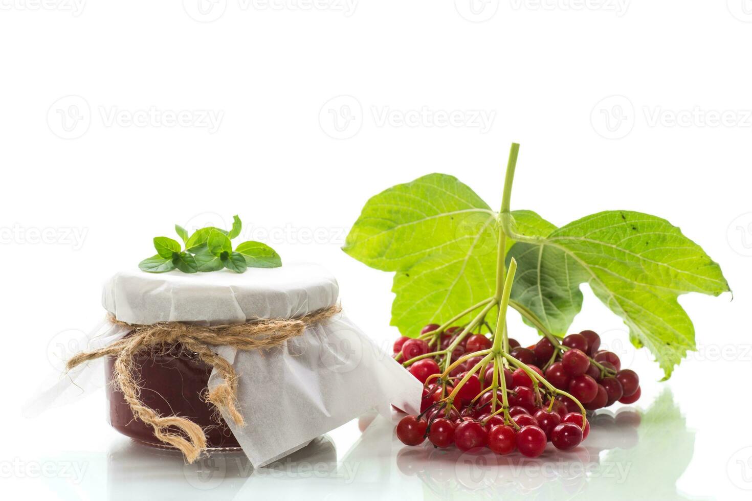 viburnum jam in a glass jar and fresh red viburnum. photo