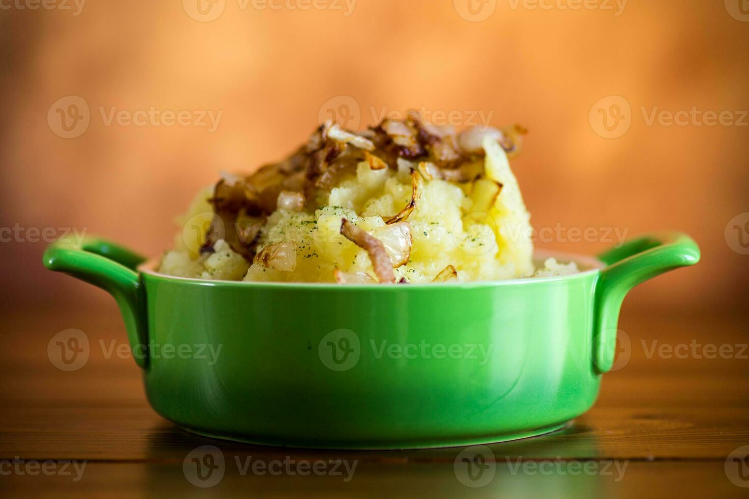 cocido machacado patatas con frito Cortado tocino y cebollas. foto