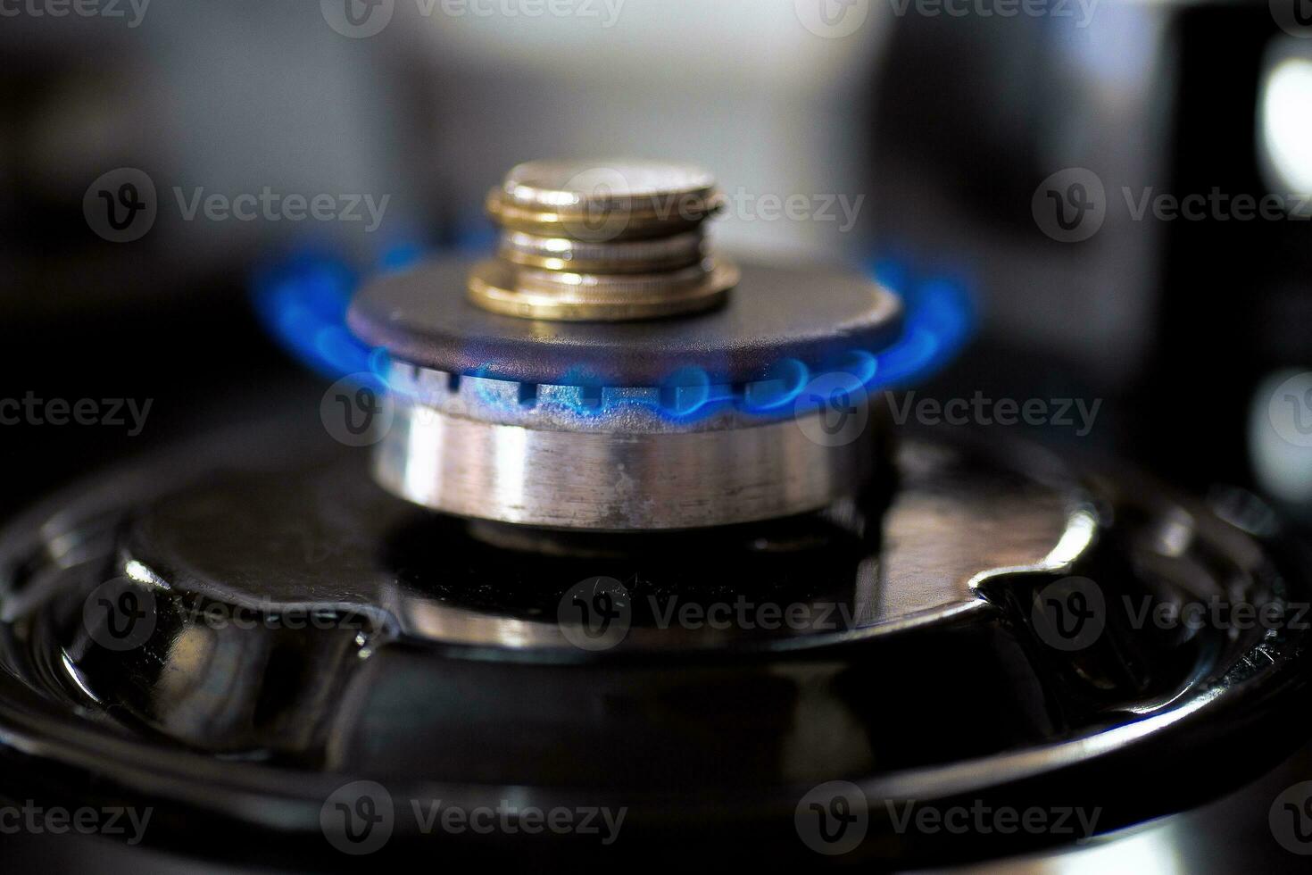 Coins accumulate on a burning gas burner. photo