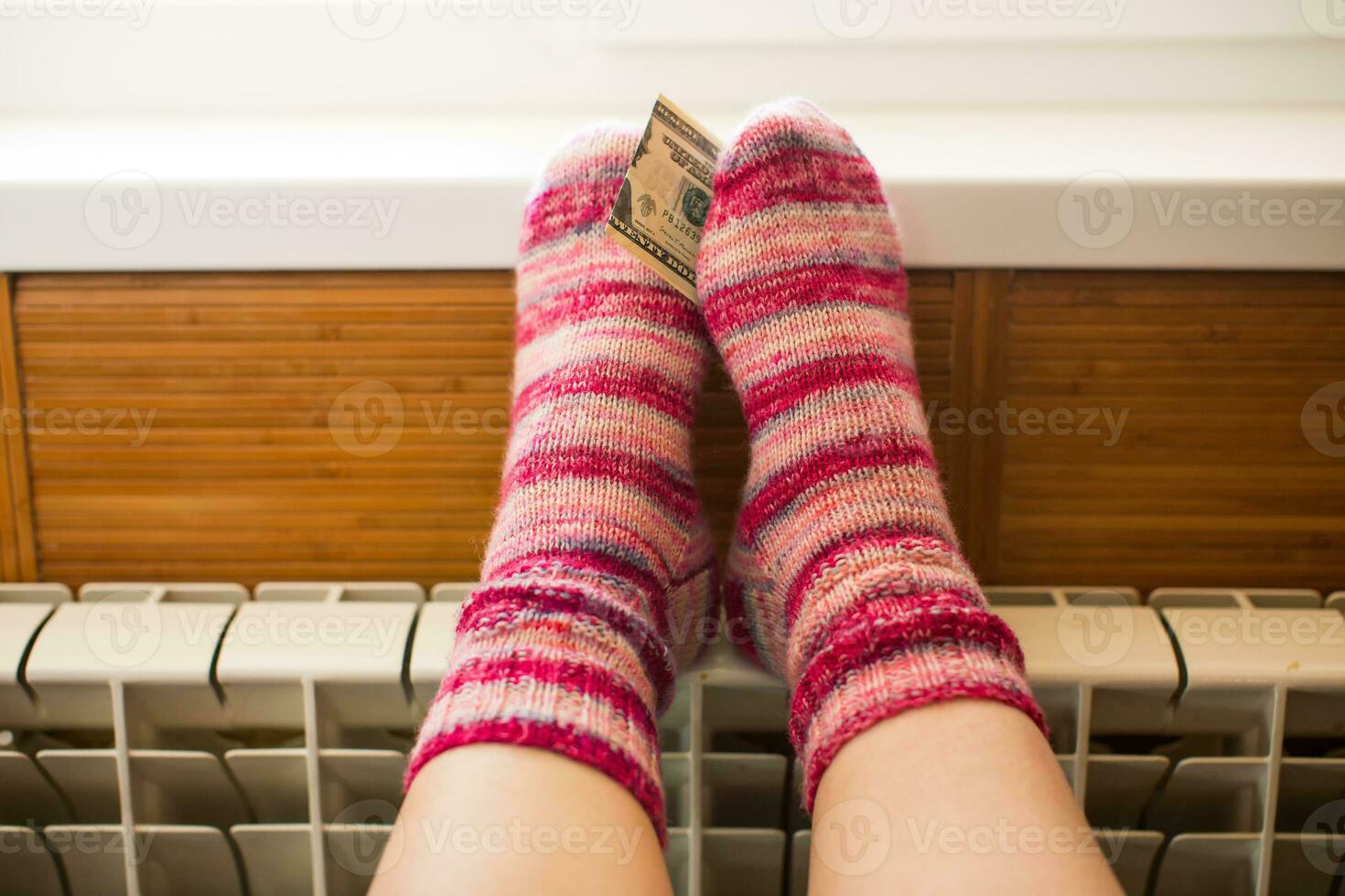 Feet in warm winter socks warm up on the radiator. photo