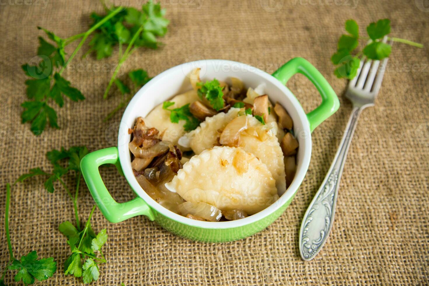 Potato dumplings with onion and mushrooms in a plate. photo