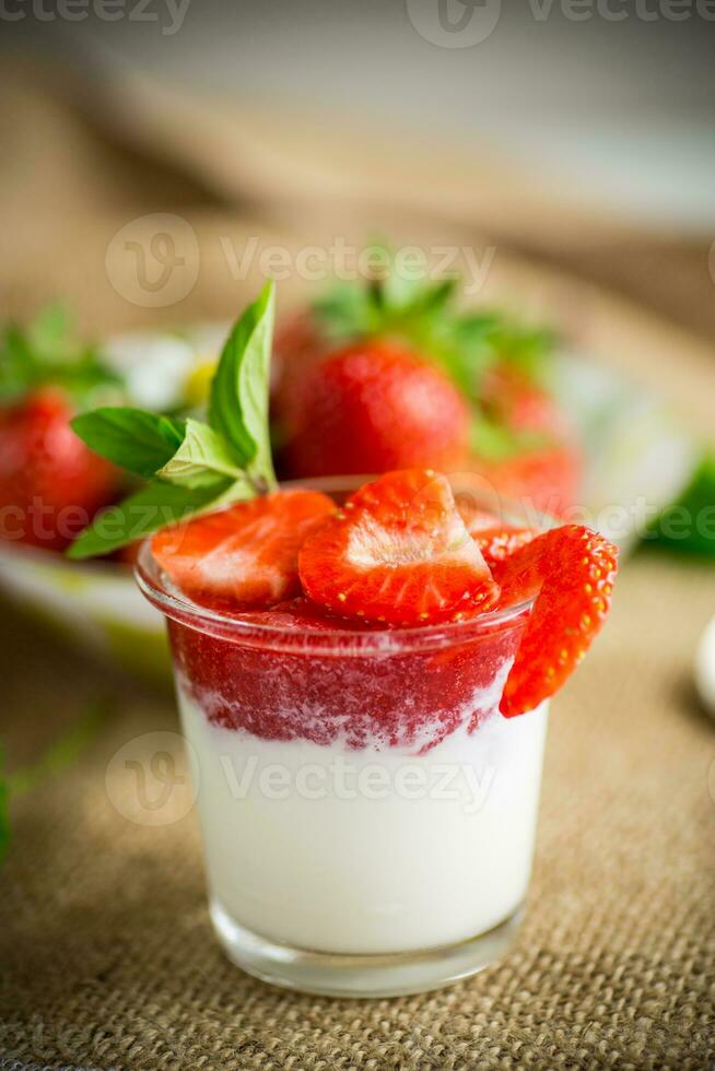 sweet homemade yogurt with strawberry jam and fresh strawberries in a glass cup photo