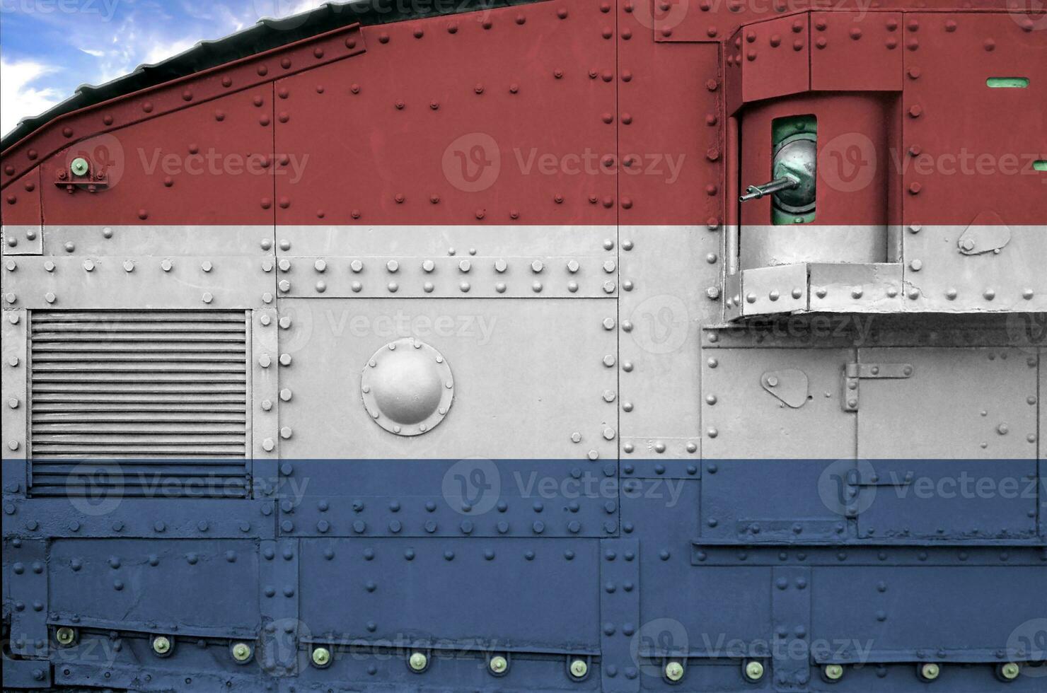 Netherlands flag depicted on side part of military armored tank closeup. Army forces conceptual background photo