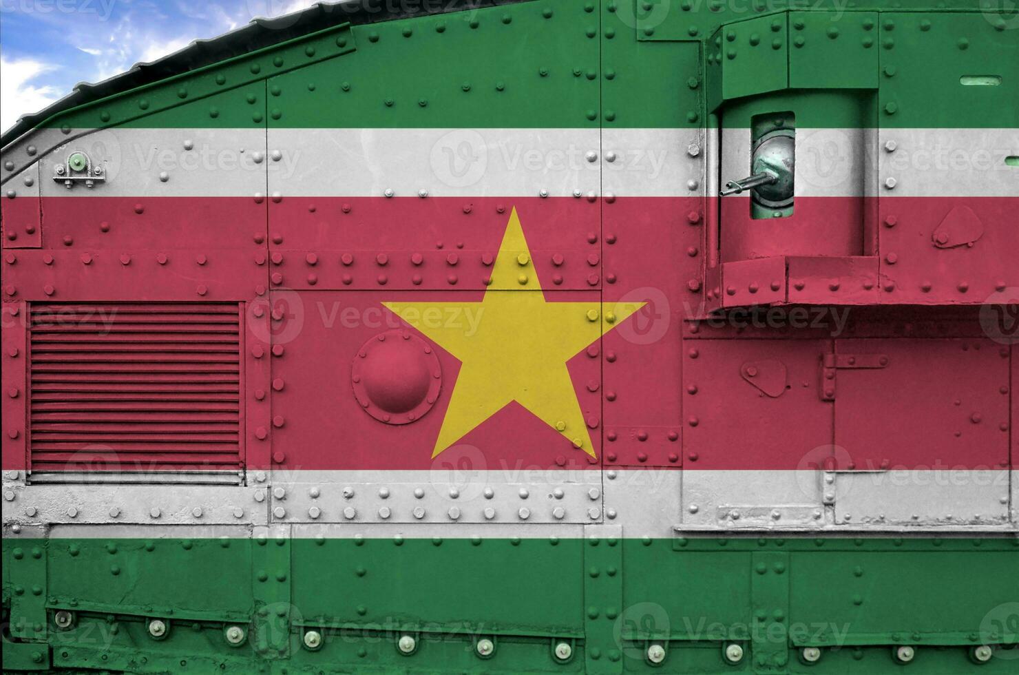 Suriname flag depicted on side part of military armored tank closeup. Army forces conceptual background photo