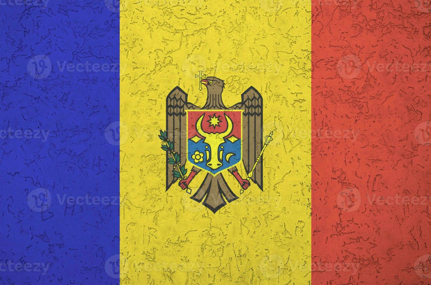 Moldova flag depicted in bright paint colors on old relief plastering wall. Textured banner on rough background photo