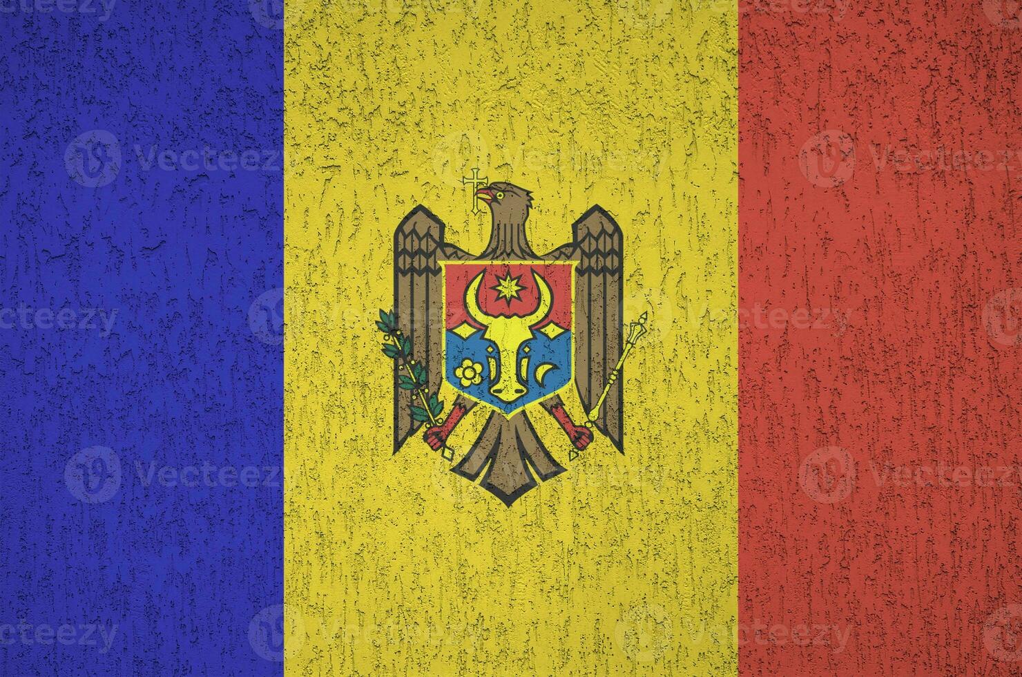 Moldova flag depicted in bright paint colors on old relief plastering wall. Textured banner on rough background photo