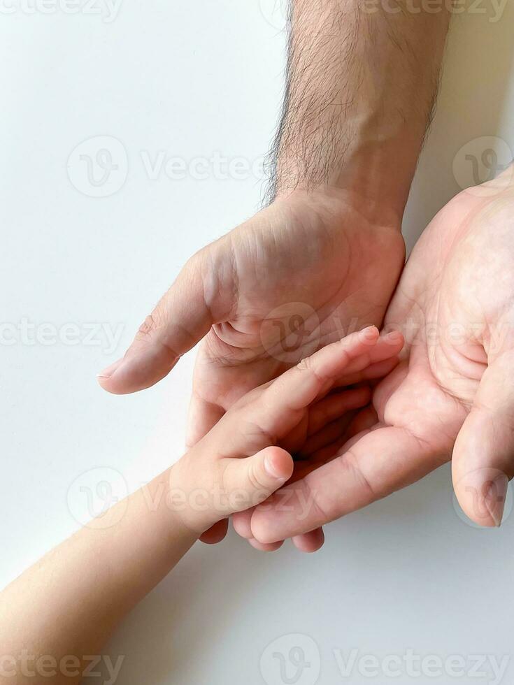 Adult and child hold their hands together. Fathers Day Child gives hand to adult photo