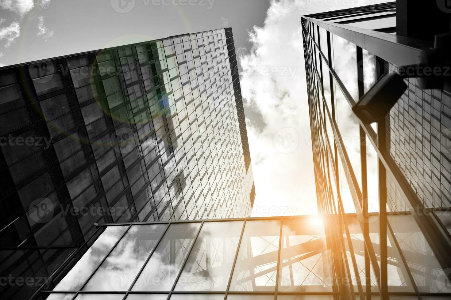 Modern architectural details. Modern glass facade with a geometric pattern. Contemporary corporate business architecture. Red sun on horizon. Black and white toned image. photo
