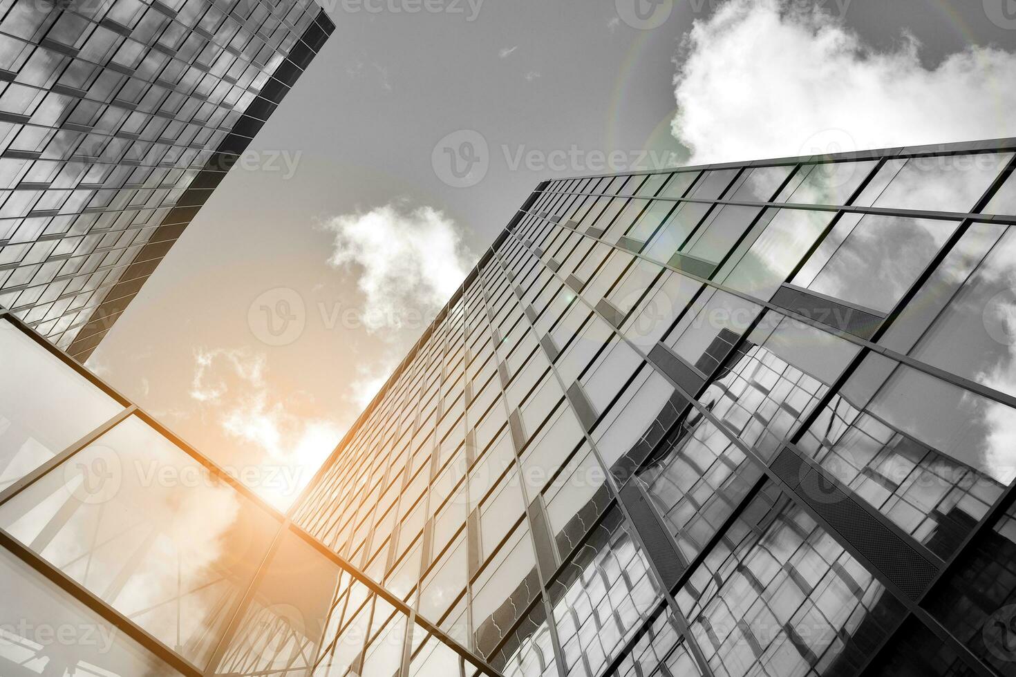 Modern architectural details. Modern glass facade with a geometric pattern. Contemporary corporate business architecture. Red sun on horizon. Black and white toned image. photo