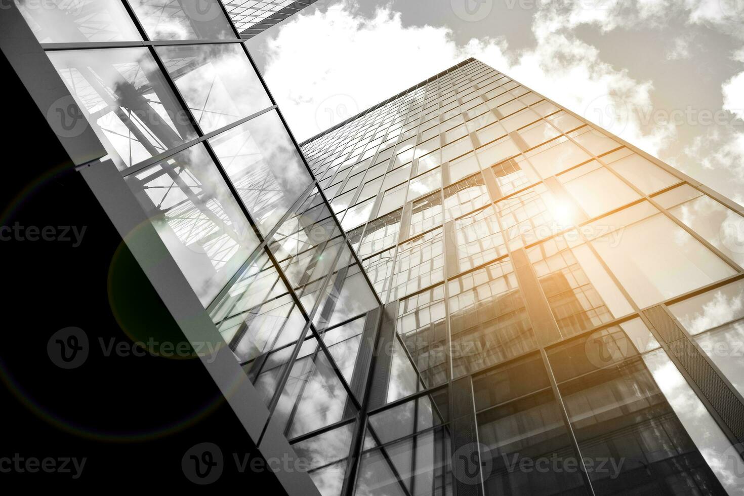 Modern architectural details. Modern glass facade with a geometric pattern. Contemporary corporate business architecture. Red sun on horizon. Black and white toned image. photo