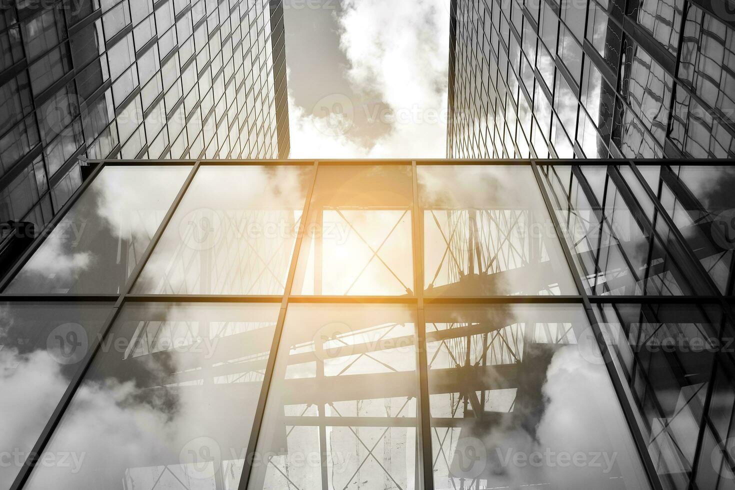 Modern architectural details. Modern glass facade with a geometric pattern. Contemporary corporate business architecture. Red sun on horizon. Black and white toned image. photo