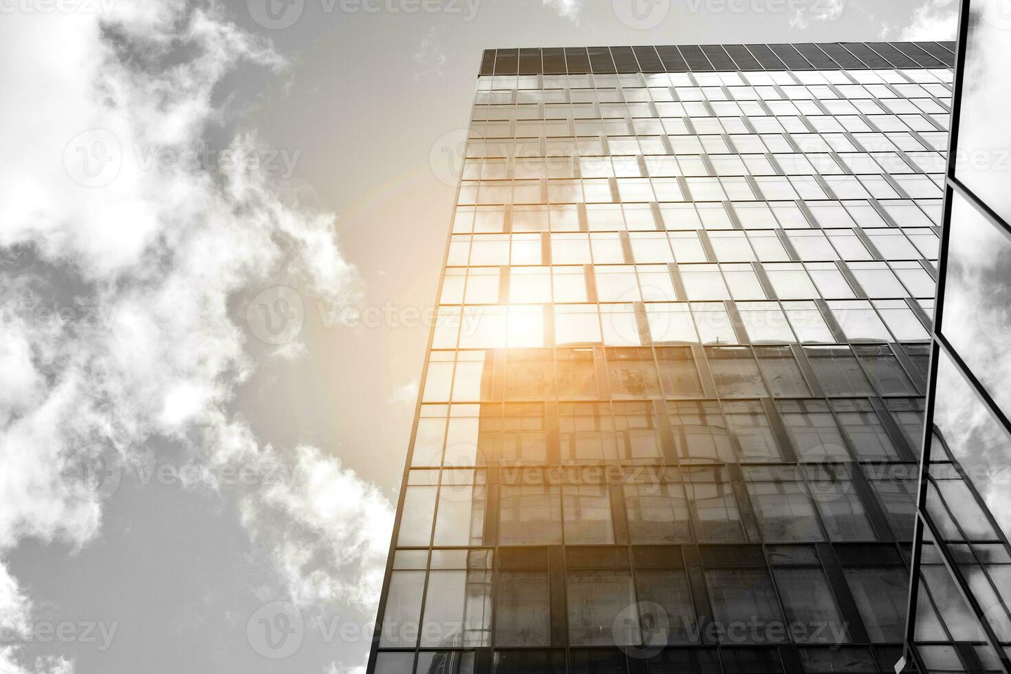 Modern architectural details. Modern glass facade with a geometric pattern. Contemporary corporate business architecture. Red sun on horizon. Black and white toned image. photo