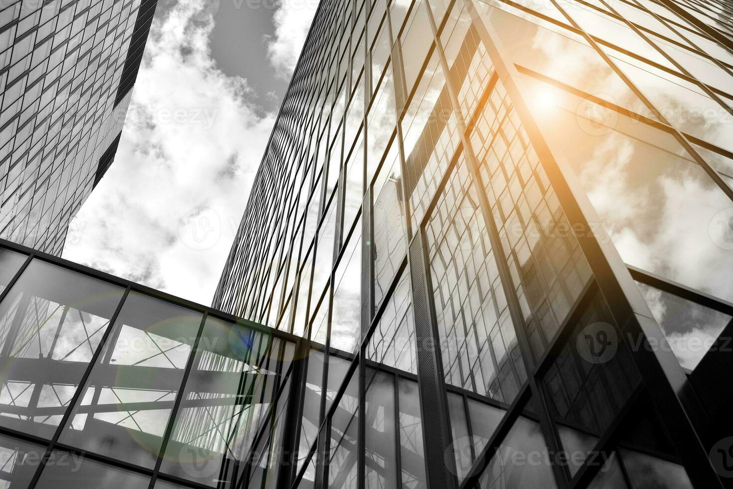 Modern architectural details. Modern glass facade with a geometric pattern. Contemporary corporate business architecture. Red sun on horizon. Black and white toned image. photo