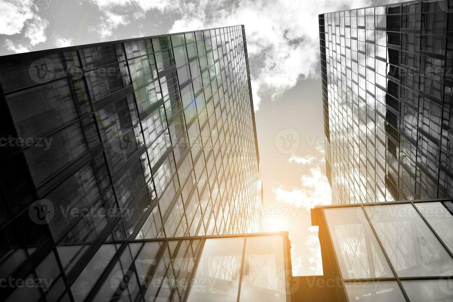 Modern architectural details. Modern glass facade with a geometric pattern. Contemporary corporate business architecture. Red sun on horizon. Black and white toned image. photo