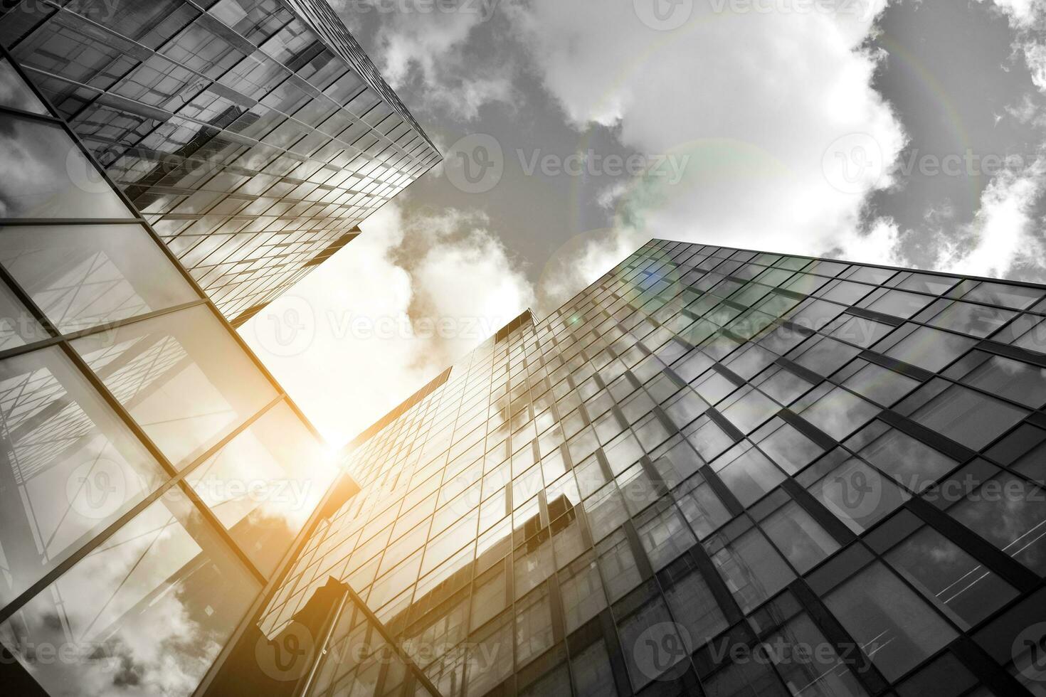 Modern architectural details. Modern glass facade with a geometric pattern. Contemporary corporate business architecture. Red sun on horizon. Black and white toned image. photo